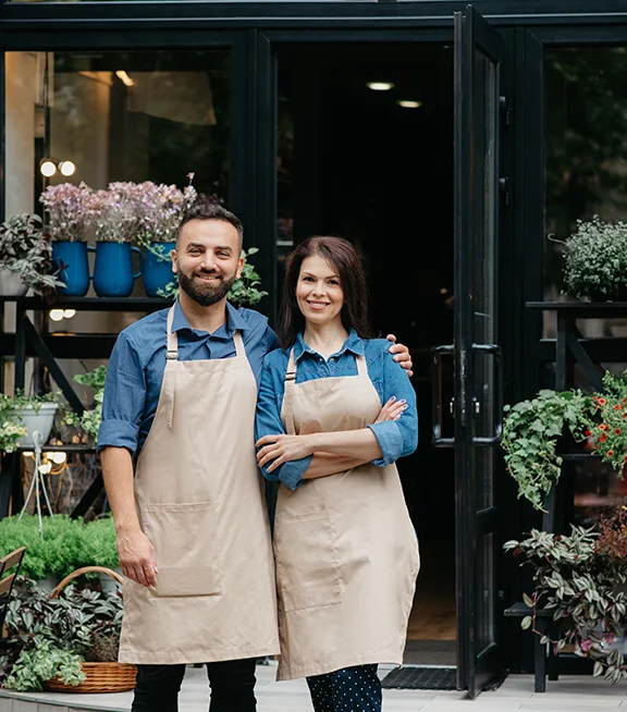 A man and woman stand outside their small, family-owned business