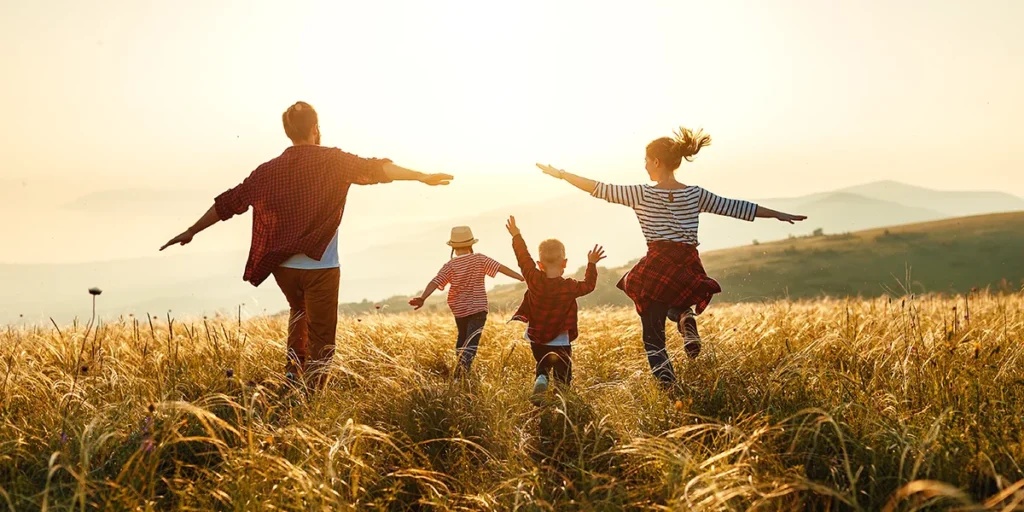 A family runs through a field, playing together